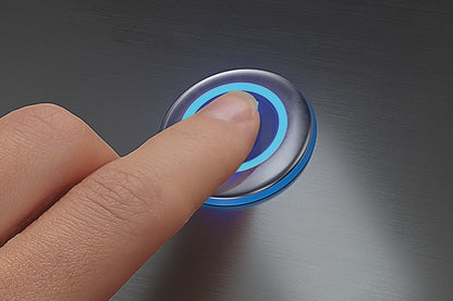 Hand pressing a button with blue light on a metallic surface